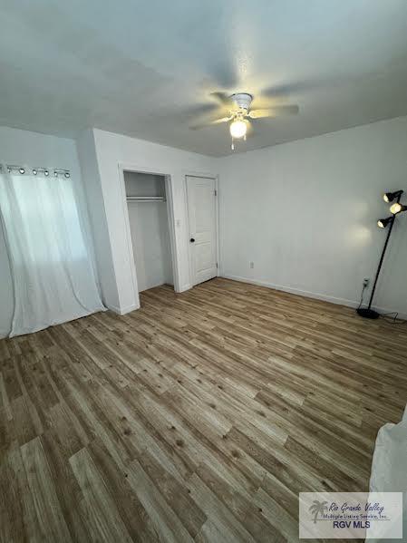 unfurnished bedroom featuring ceiling fan and wood-type flooring