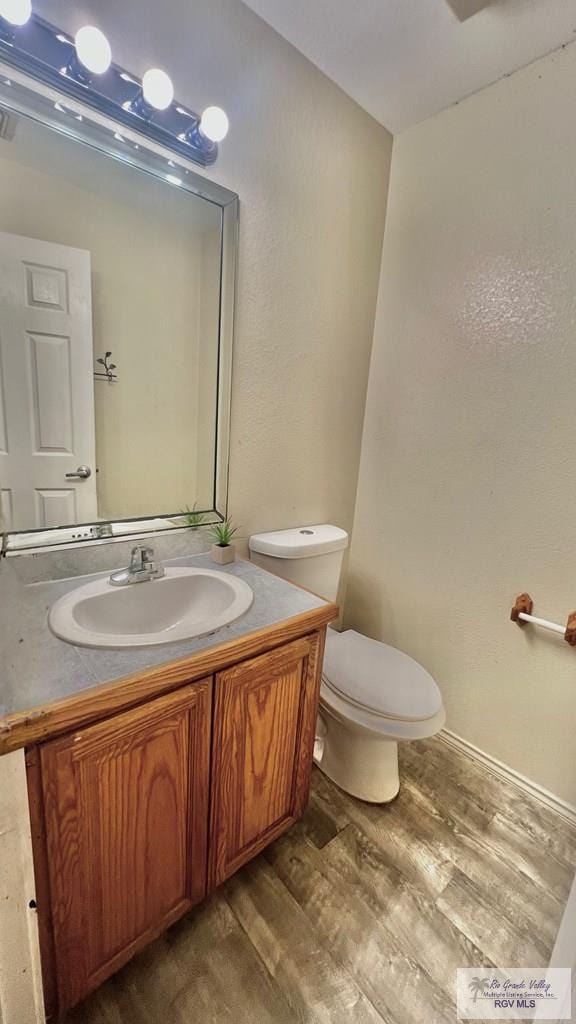 2839 Regency Dr, Brownsville, TX 78526 - bathroom featuring wood finished floors, toilet, and vanity