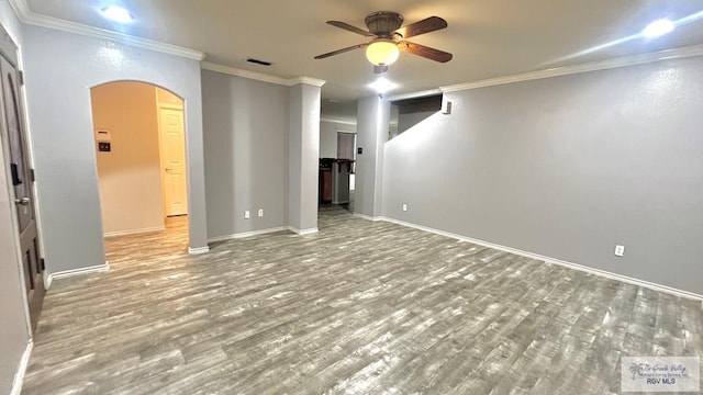 2839 Regency Dr, Brownsville, TX 78526 - empty room featuring arched walkways, a ceiling fan, wood finished floors, ornamental molding, and baseboards