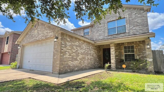 2839 Regency Dr, Brownsville, TX 78526 - traditional home with an attached garage, concrete driveway, and brick siding