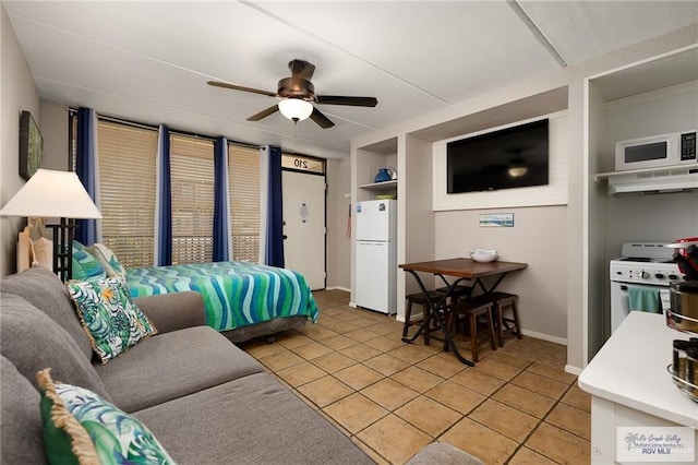 110 E Pompano St, South Padre Island, TX 78587 - bedroom with freestanding refrigerator, light tile patterned floors, baseboards, and a ceiling fan