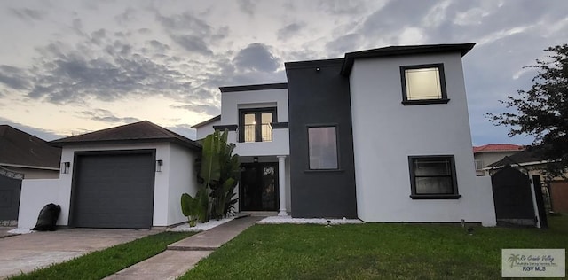 contemporary house featuring a yard and a garage