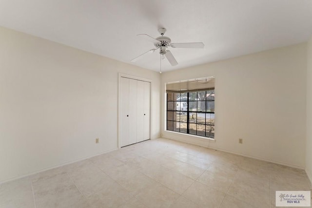 spare room with ceiling fan and light tile patterned flooring