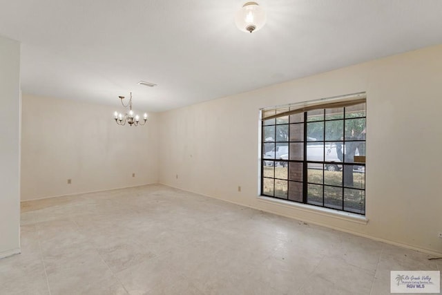 unfurnished room with a chandelier