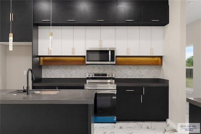 kitchen with appliances with stainless steel finishes, tasteful backsplash, sink, white cabinetry, and hanging light fixtures