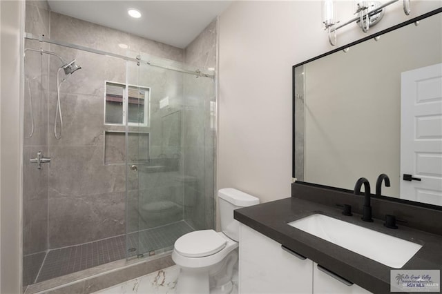 bathroom featuring vanity, toilet, and a shower with door