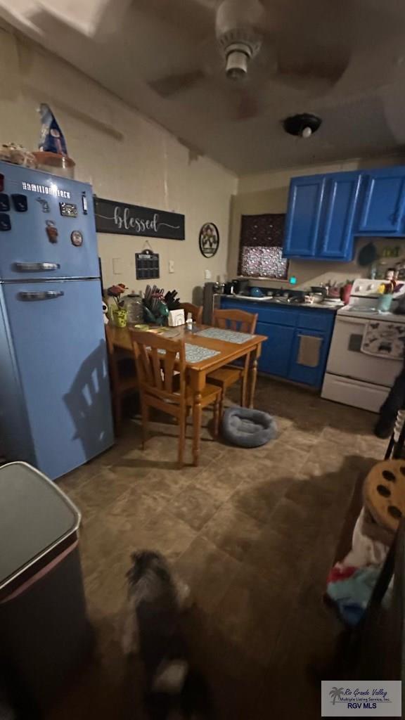 kitchen featuring ceiling fan, blue cabinetry, electric range, and refrigerator