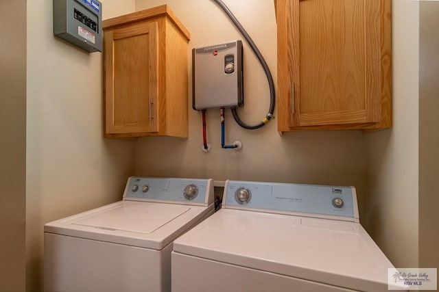 laundry room with cabinets, independent washer and dryer, and water heater