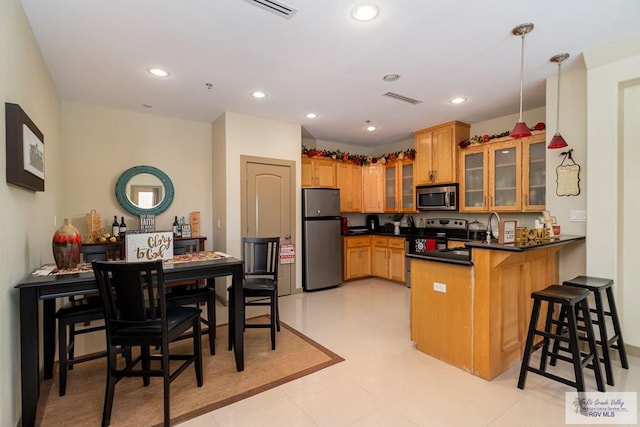 kitchen with a breakfast bar, sink, hanging light fixtures, kitchen peninsula, and stainless steel appliances