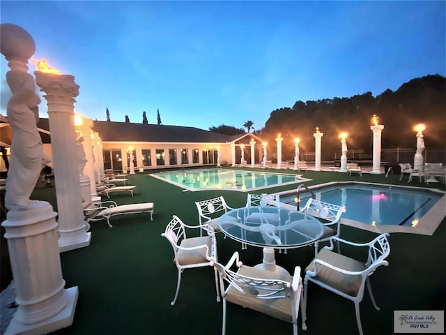 view of pool at dusk