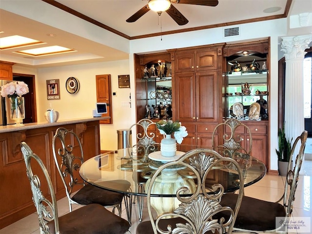 dining space featuring decorative columns, ceiling fan, light tile patterned floors, and ornamental molding