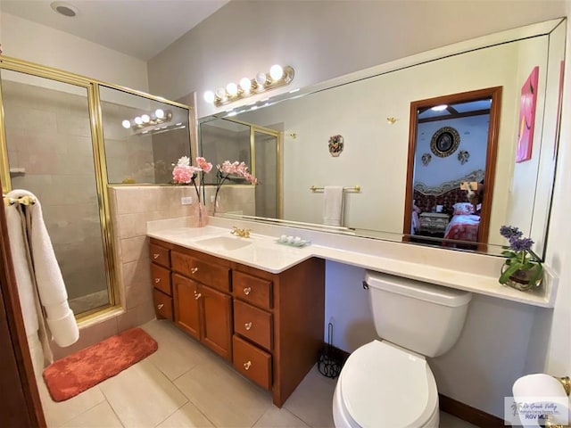 bathroom featuring tile patterned floors, toilet, vanity, and walk in shower