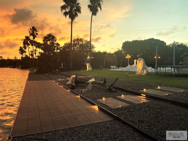 patio terrace at dusk featuring a yard and a trampoline