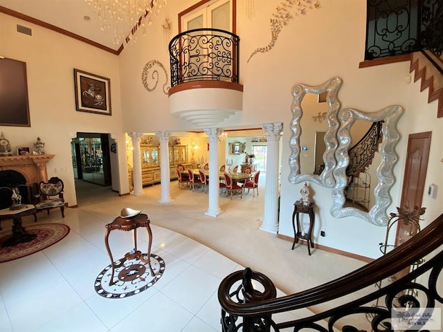 entryway featuring carpet, decorative columns, and high vaulted ceiling