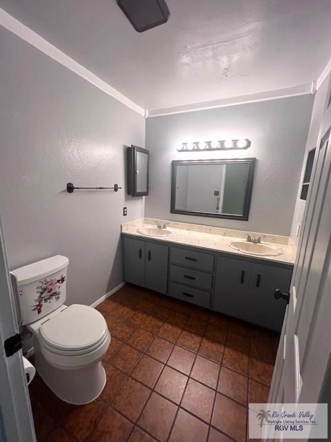 bathroom featuring vanity, tile patterned flooring, crown molding, and toilet