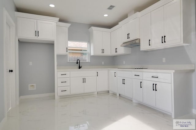 kitchen with white cabinets, black electric stovetop, and sink