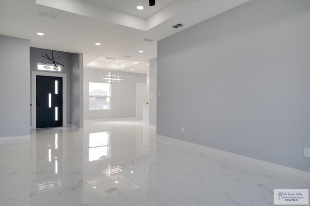 foyer entrance featuring a tray ceiling and ceiling fan