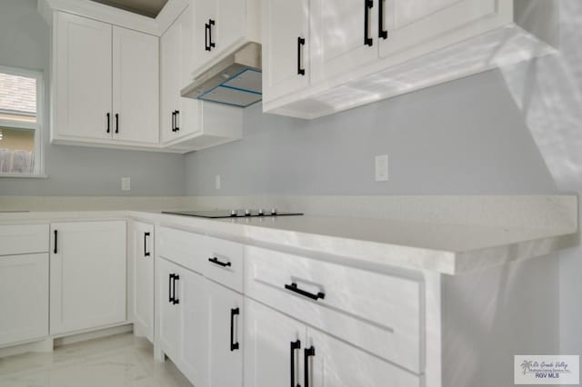 kitchen featuring black electric cooktop and white cabinets