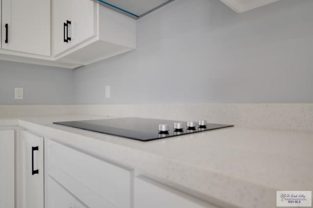 kitchen featuring white cabinetry and black electric cooktop