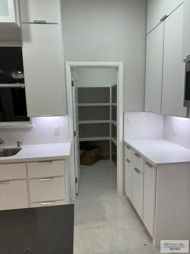 kitchen featuring white cabinets and sink