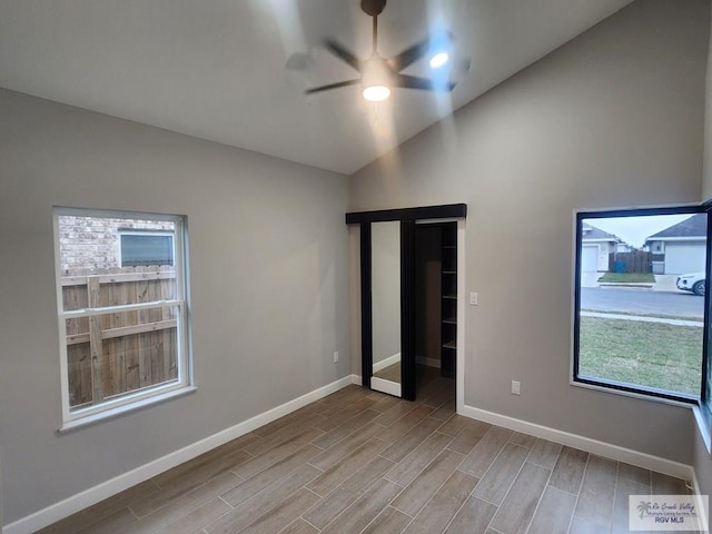 unfurnished bedroom featuring ceiling fan, lofted ceiling, and light wood-type flooring