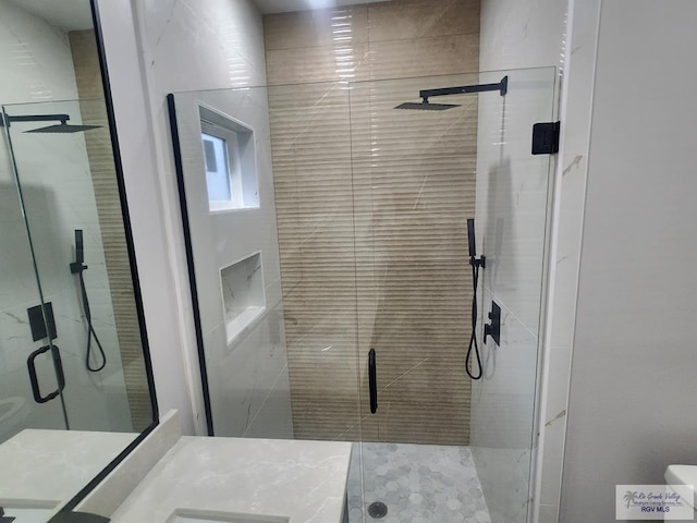 bathroom with walk in shower and vanity