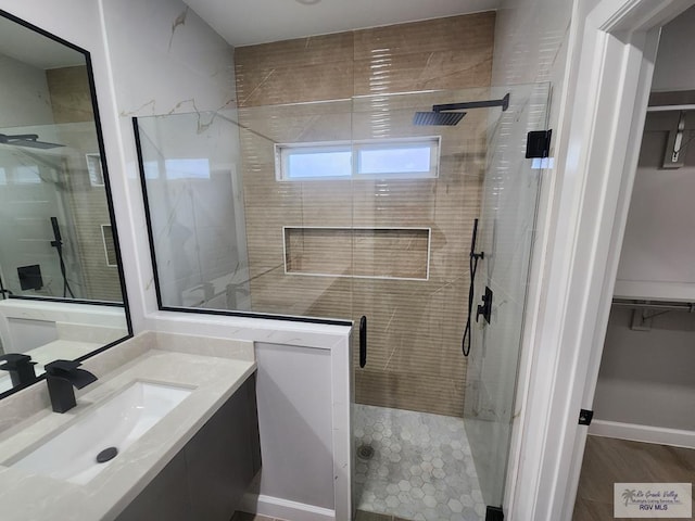 bathroom with vanity, hardwood / wood-style flooring, and walk in shower