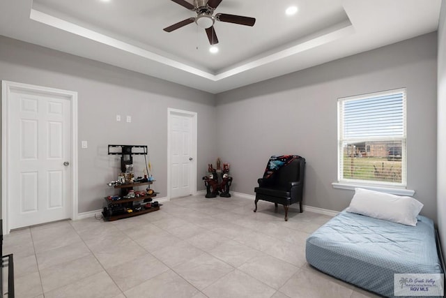 sitting room with light tile patterned floors, baseboards, and a raised ceiling