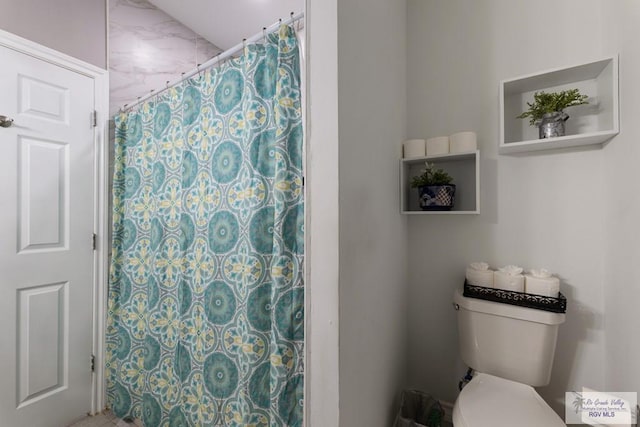 bathroom with toilet and a shower with curtain