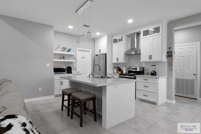 kitchen featuring open shelves, a sink, visible vents, appliances with stainless steel finishes, and wall chimney exhaust hood