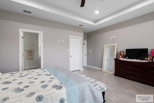 bedroom featuring baseboards, visible vents, a raised ceiling, and light tile patterned flooring