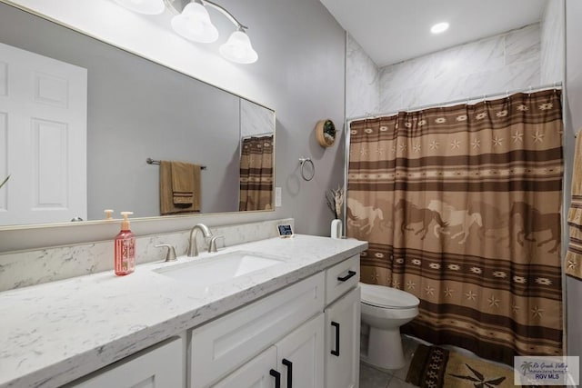 bathroom featuring toilet, a shower with shower curtain, and vanity