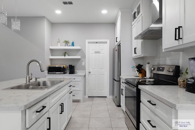 kitchen featuring stainless steel appliances, a sink, white cabinets, wall chimney range hood, and open shelves