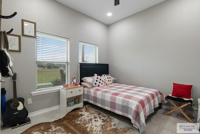 tiled bedroom with baseboards and a ceiling fan