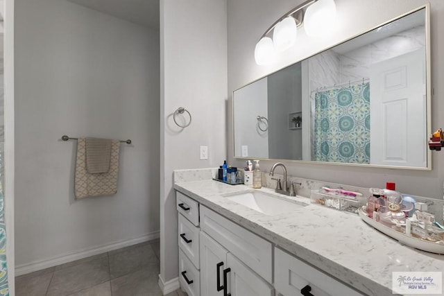 bathroom with curtained shower, tile patterned flooring, vanity, and baseboards