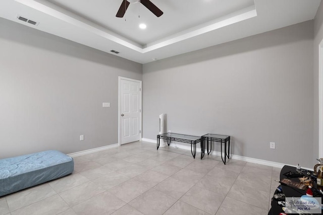 interior space featuring a raised ceiling, visible vents, and baseboards