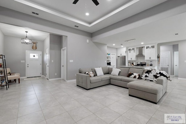 living area featuring light tile patterned flooring, visible vents, and baseboards