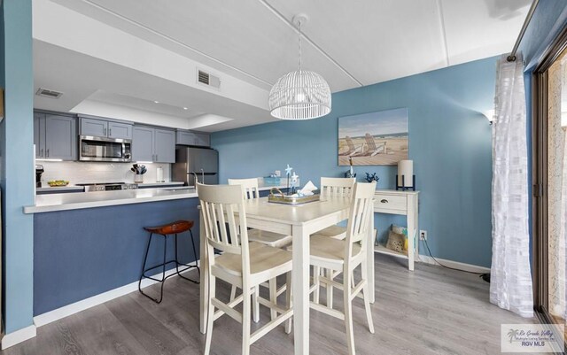 111 E Morningside Dr Unit 209, South Padre Island, TX 78597 - dining space featuring a raised ceiling and wood finished floors