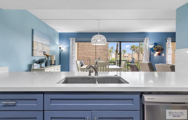 111 E Morningside Dr Unit 209, South Padre Island, TX 78597 - kitchen with stainless steel dishwasher, decorative light fixtures, light countertops, and blue cabinetry