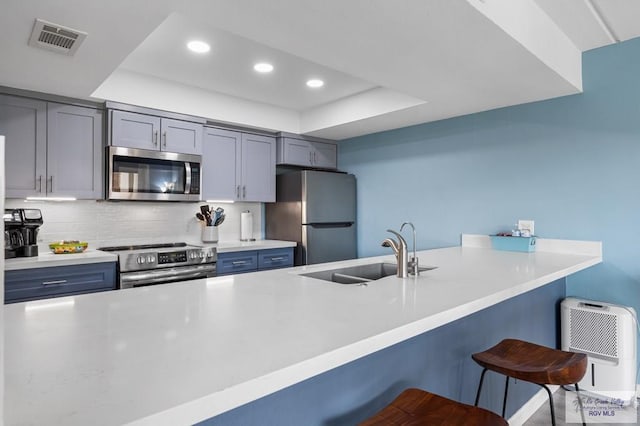 111 E Morningside Dr Unit 209, South Padre Island, TX 78597 - kitchen with stainless steel appliances, a tray ceiling, recessed lighting, a kitchen breakfast bar, and heating unit