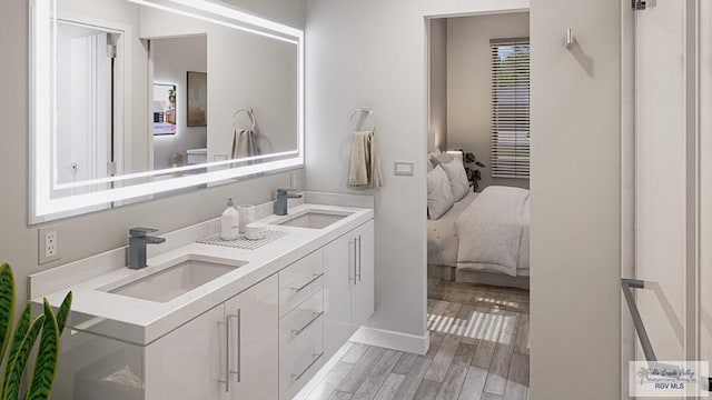 234 Cameo Dr, San Benito, TX 78586 - bathroom with double vanity, ensuite bath, wood finished floors, and baseboards