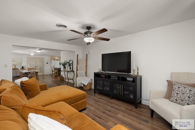 living room featuring a ceiling fan, visible vents, and wood finished floors