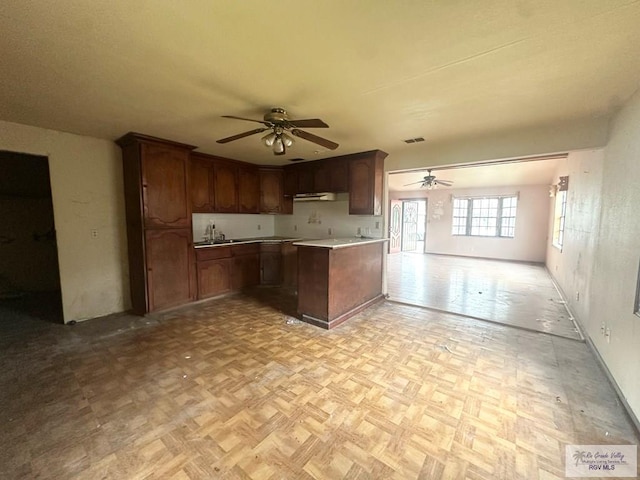 22920 Angel St, Harlingen, TX 78552 - kitchen featuring a ceiling fan, open floor plan, light countertops, a sink, and under cabinet range hood