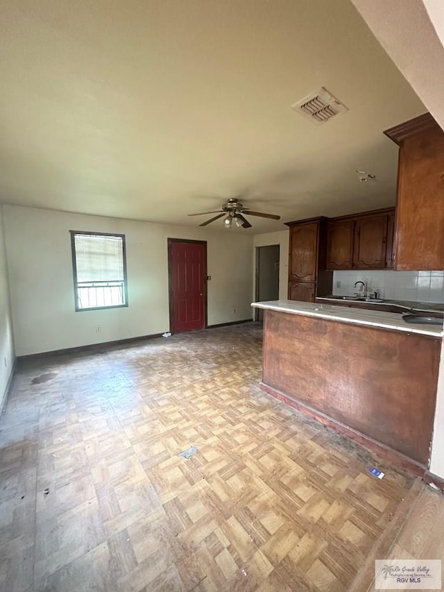 22920 Angel St, Harlingen, TX 78552 - kitchen featuring baseboards, ceiling fan, open floor plan, a peninsula, and light countertops