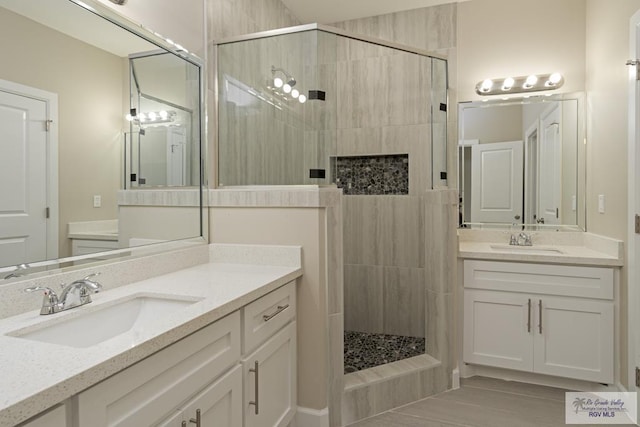 bathroom featuring a tile shower and vanity