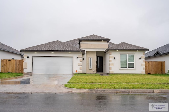 prairie-style home with a front lawn and a garage