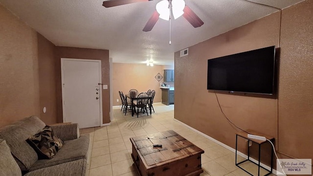 tiled living room featuring a textured ceiling and ceiling fan