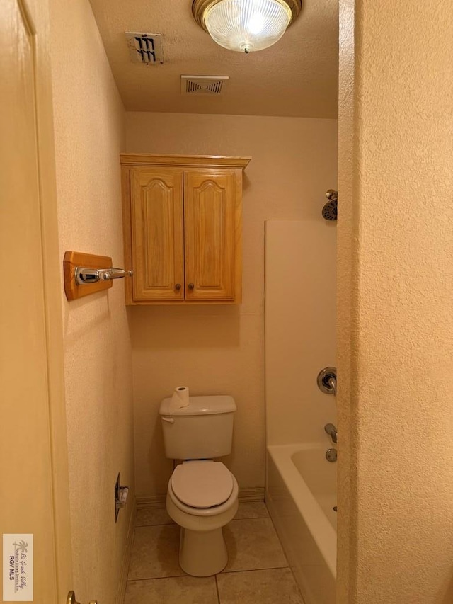 bathroom featuring tile patterned flooring, shower / bath combination, a textured ceiling, and toilet