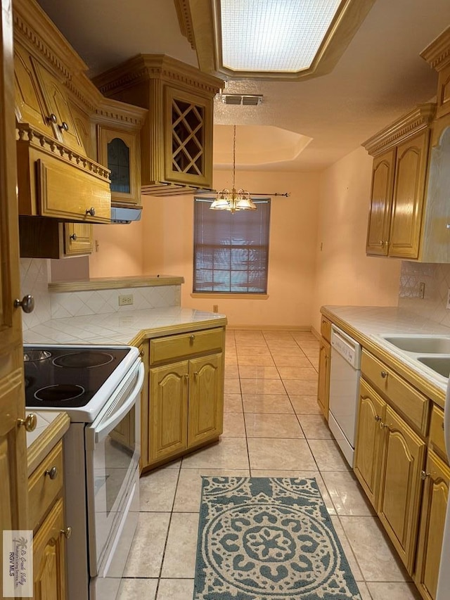 kitchen featuring tasteful backsplash, white appliances, light tile patterned floors, tile countertops, and decorative light fixtures