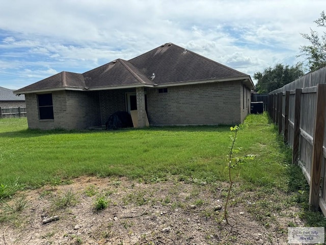 rear view of property featuring a lawn